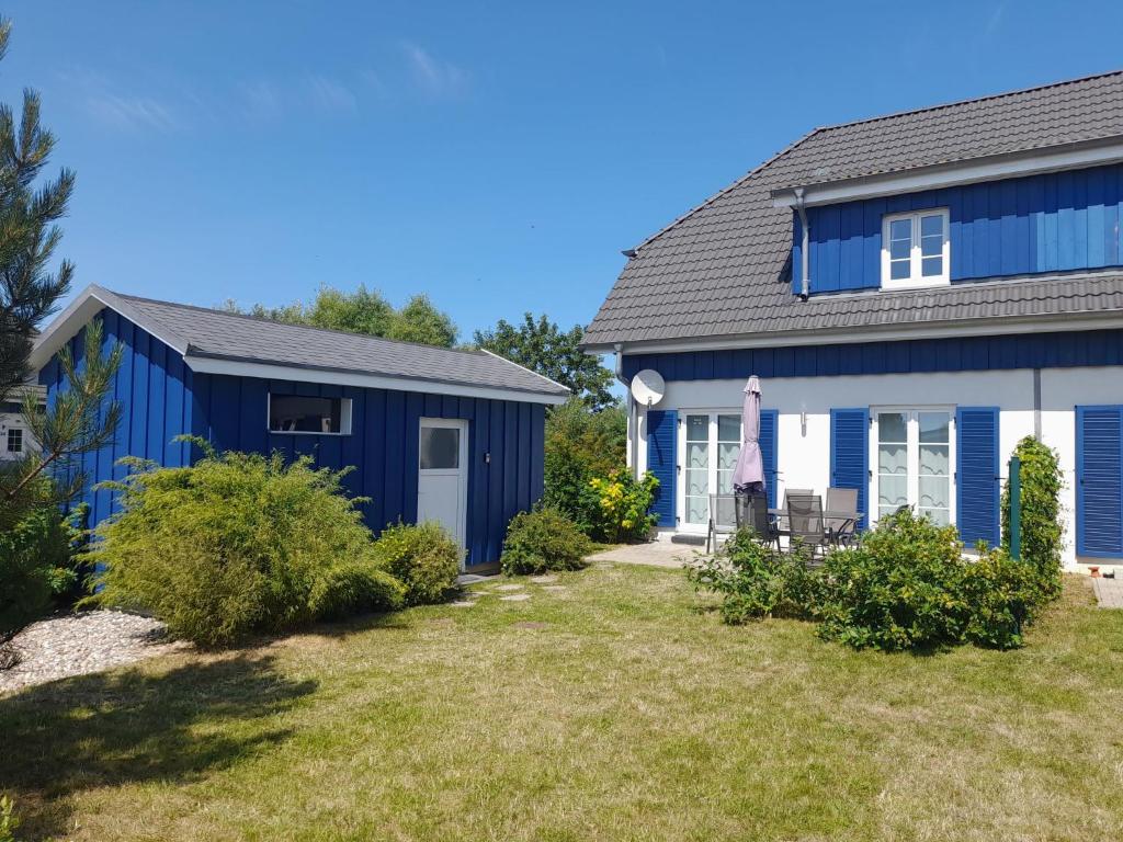 a blue and white house with a yard at Holiday Home Sanddorn by Interhome in Altefähr