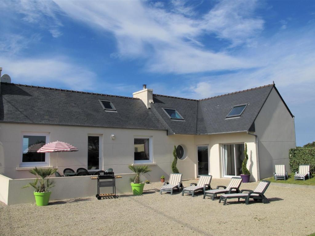 Casa blanca con sillas y sombrilla en Holiday Home Brise Marine by Interhome, en Cléder
