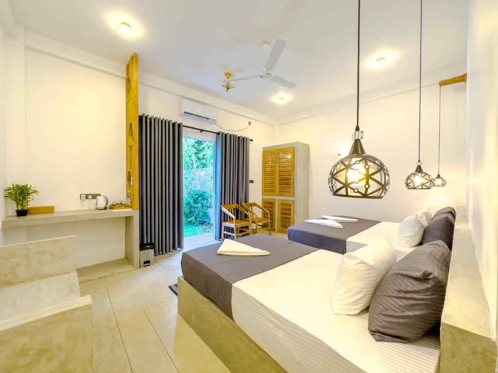 um quarto de hotel com duas camas e uma cozinha em Moringa Mirissa em Mirissa