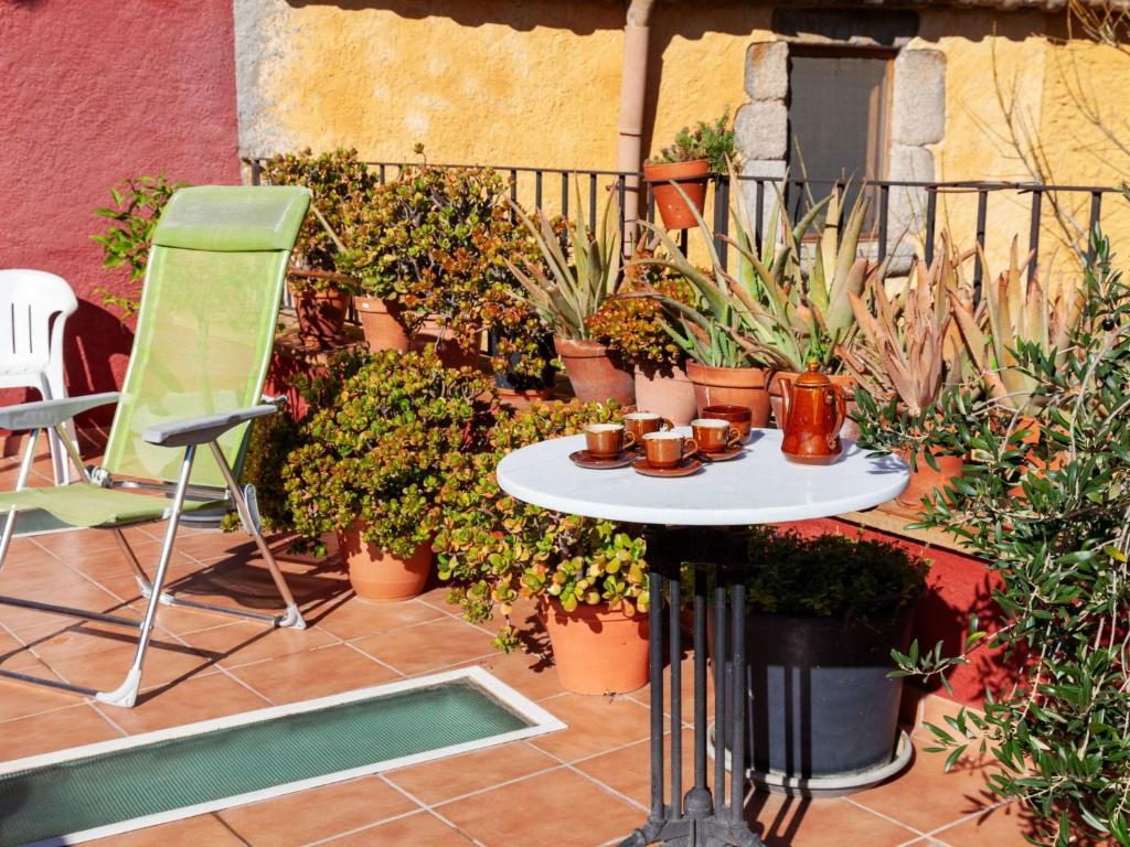 カロンジェにあるHoliday Home Sant Joan by Interhomeのパティオ(テーブル、椅子、鉢植えの植物付)