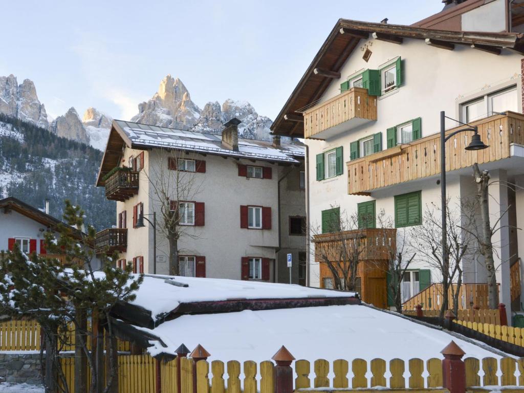 um grupo de edifícios com neve no chão em Apartment Deluca - PFS466 by Interhome em Pozza di Fassa