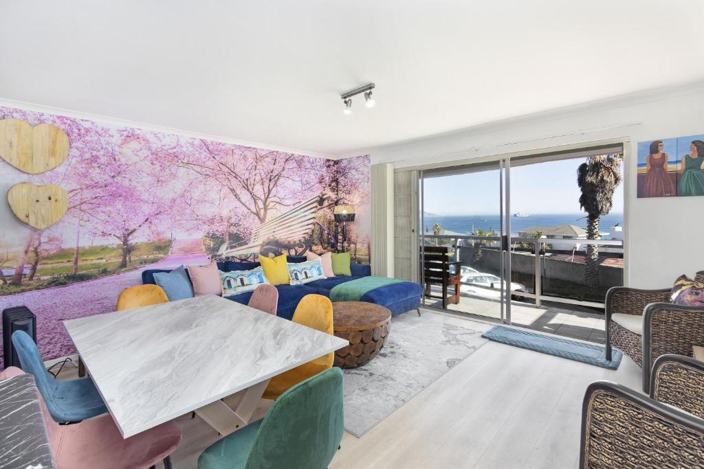 a living room with a table and chairs at Coral Island 102 in Bloubergstrand