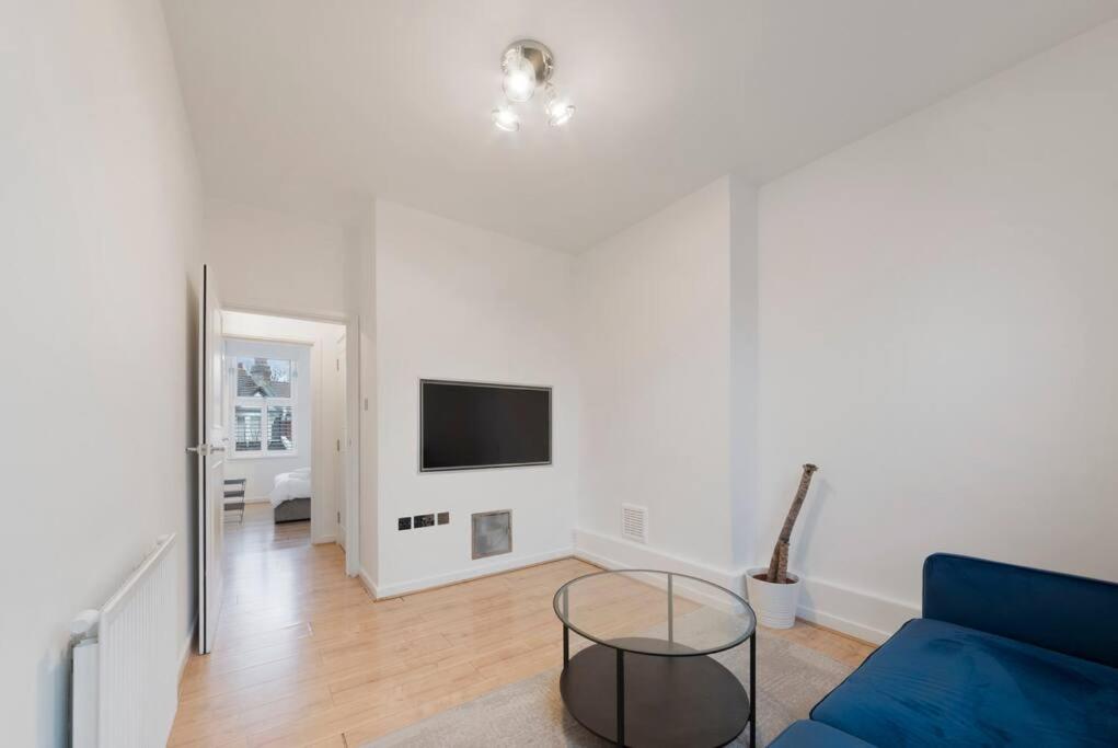 a living room with a blue couch and a tv at Stunning 1-bed Flat in London 20 mins from Central London in London