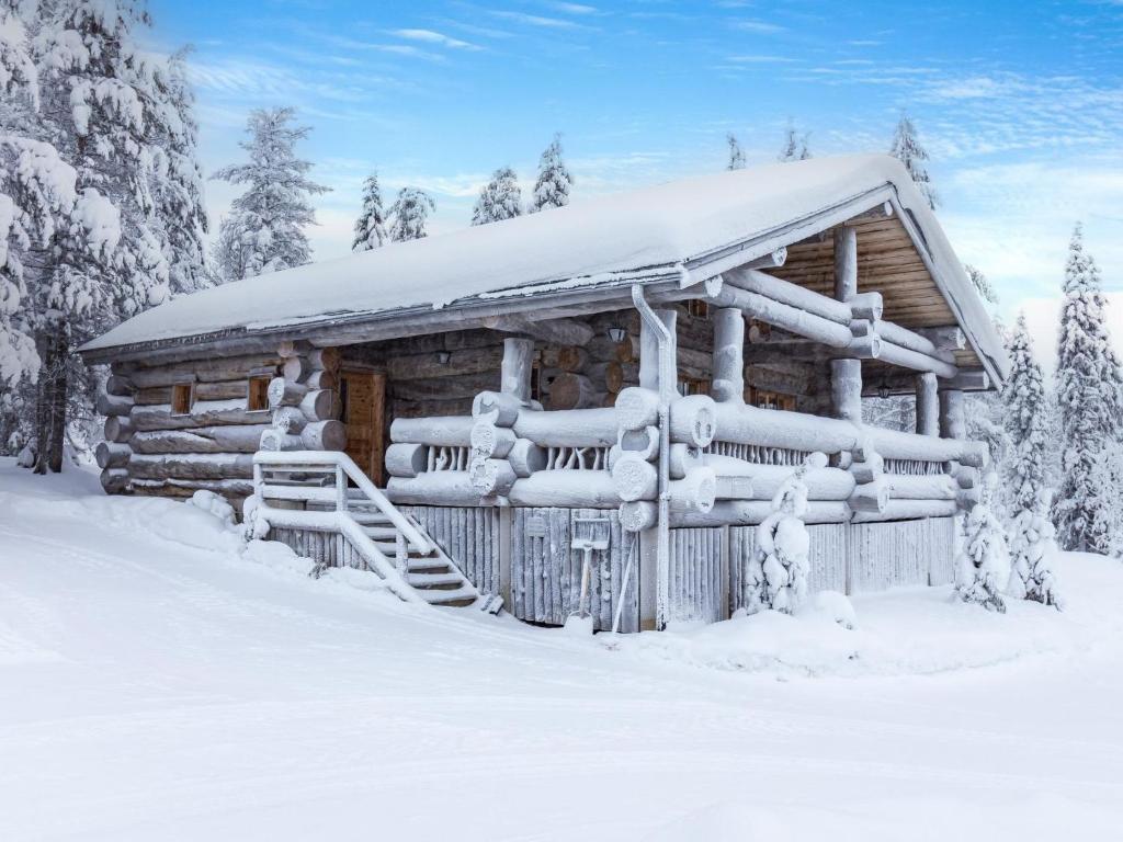 una baita di tronchi ricoperta di neve nei boschi di Holiday Home Kitka-nokkela by Interhome a Ruka