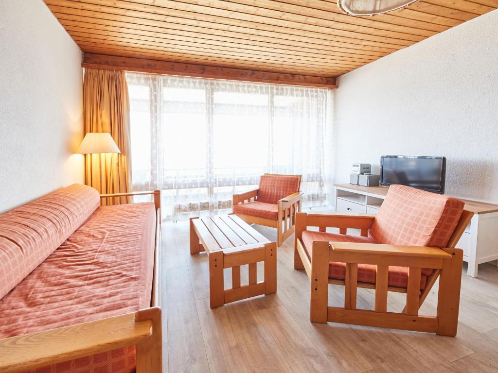 Zimmer mit einem Bett und Stühlen sowie einem TV in der Unterkunft Apartment Flache 401 by Interhome in Les Collons