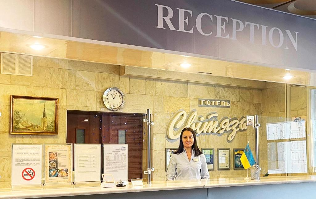a woman standing behind a counter in a restaurant at Svytyaz Hotel in Lutsk