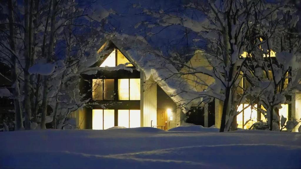 Una casa en la nieve por la noche en Niseko White Villas1, en Niseko