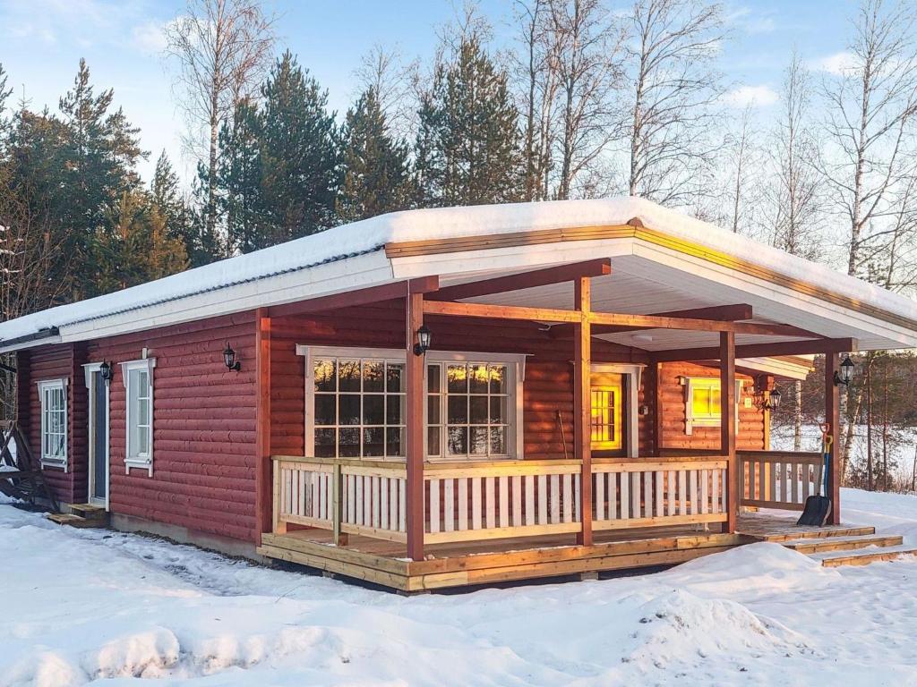 a log cabin with a porch in the snow at Holiday Home Lassinmaja by Interhome in Hara