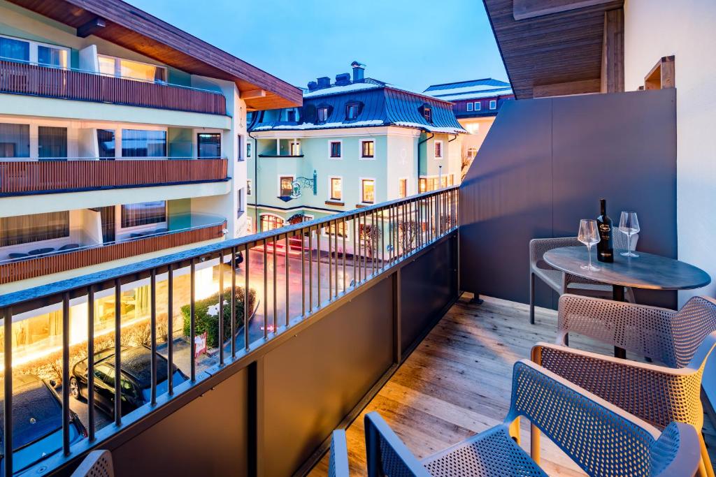 un balcone con sedie e tavolo su un edificio di Hotel Grüner Baum a Zell am See