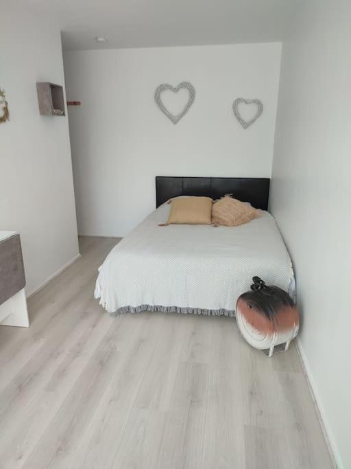 une chambre blanche avec un lit et un parquet dans l'établissement studio avec piscine, à Gruissan
