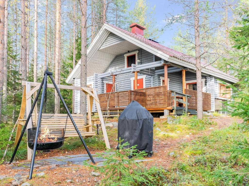 una casa nel bosco con una tenda di fronte di Holiday Home Kanerva by Interhome ad Ahmovaara