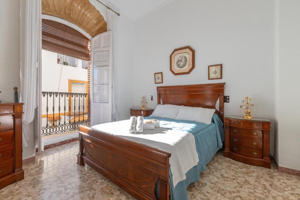 1 dormitorio con 1 cama grande y balcón en Casa Margarita, en Cañete la Real