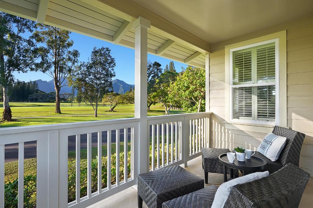 a porch with chairs and a table with a view at Casa Makara in Princeville