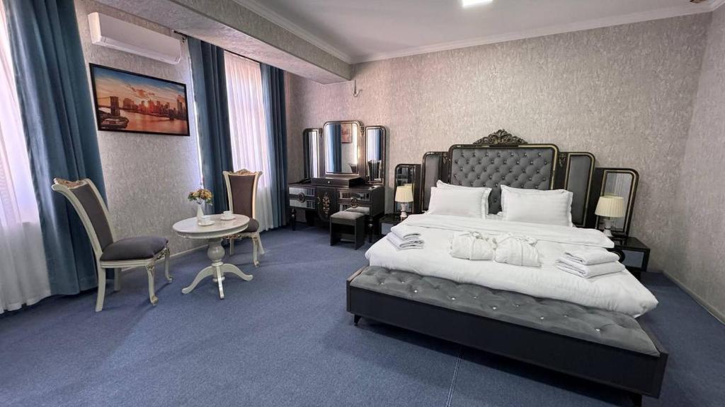 a bedroom with a large bed and a desk at Gumbaz Luxury hotel in Bukhara