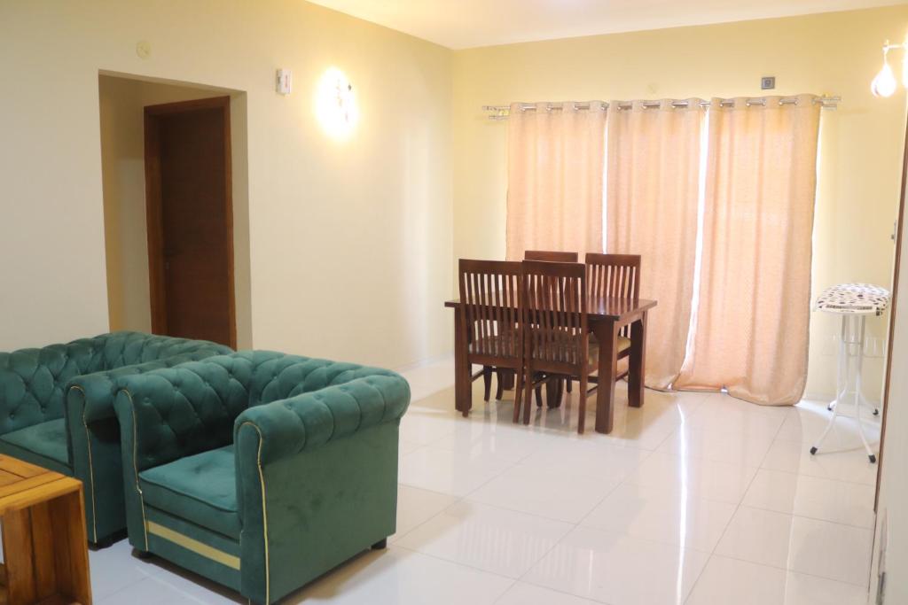 een woonkamer met een bank en een tafel bij Tanour stay in Bangalore