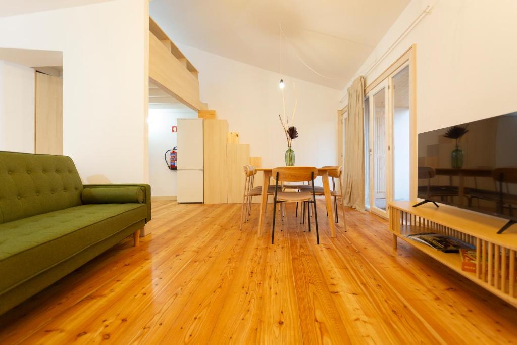 a living room with a green couch and a table at Vinum Apartament 1890 in Coimbra
