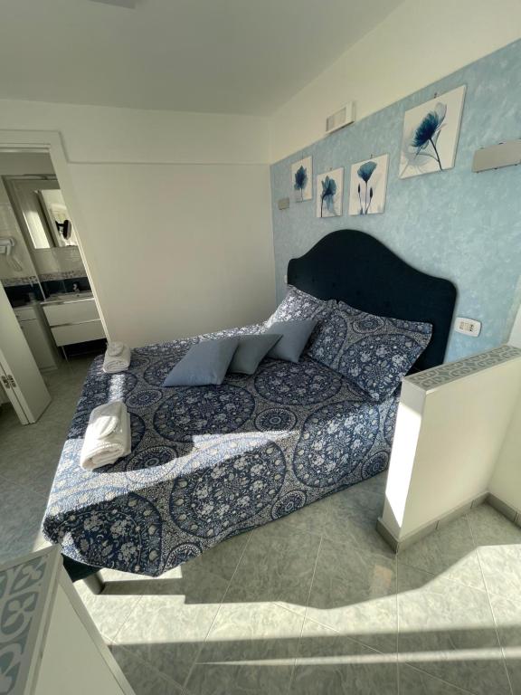 een slaapkamer met een bed met een blauw en wit dekbed bij camera vista mare in Anacapri