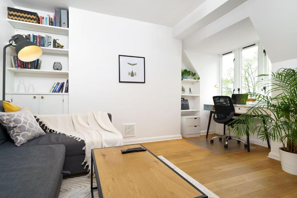 a living room with a couch and a table at Lovely Apartment in Victoria Park Village in London