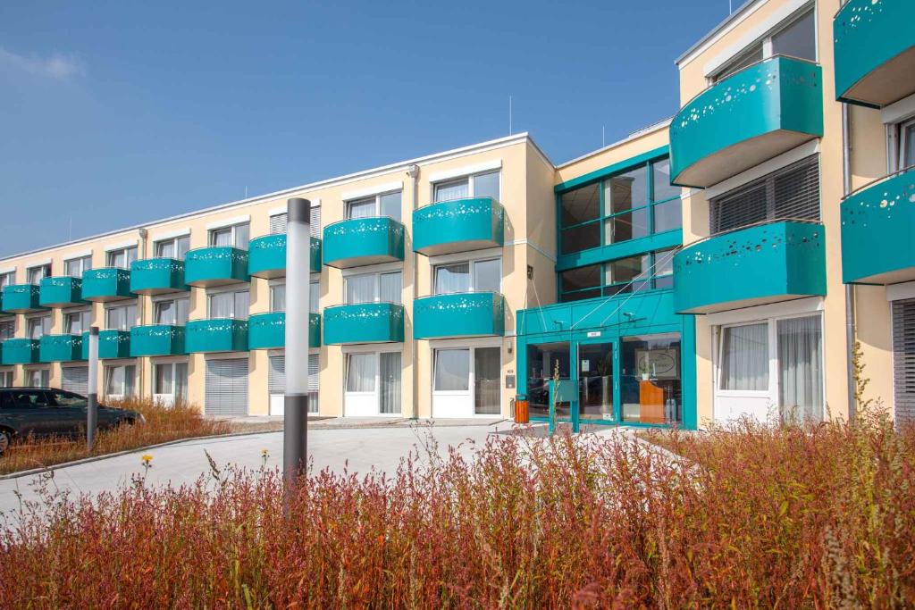 an apartment building with blue balconies and a parking lot at Apartments in Erding - Oberbayern 36757 in Erding