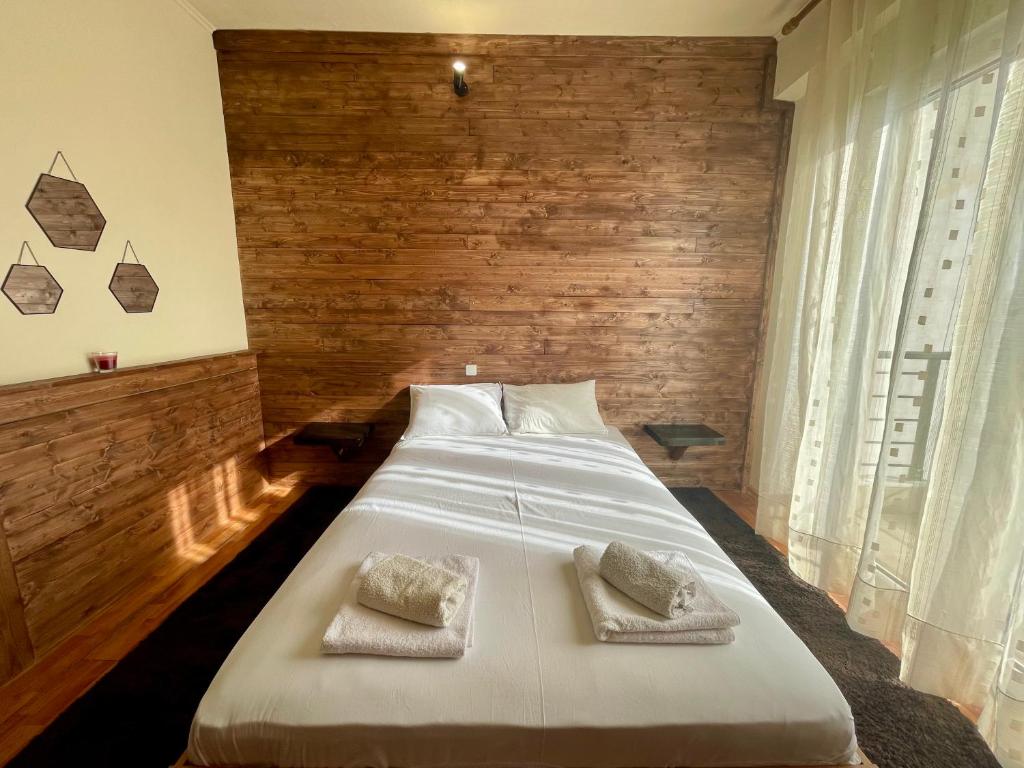 a bedroom with a large white bed with two pillows at Woodstay Apartments in Orestiada
