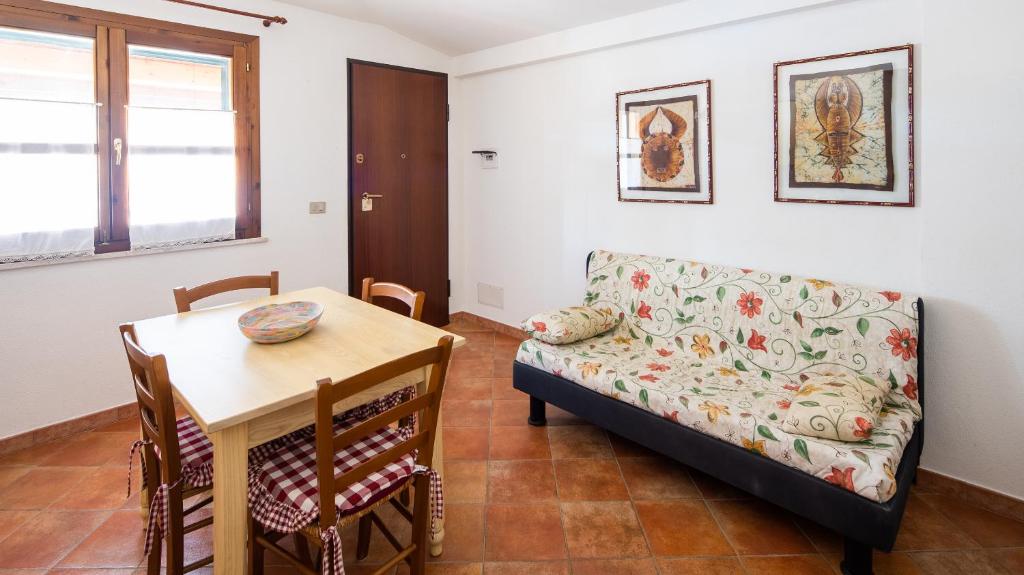a living room with a couch and a table at Meraviglioso bilocale a 700metri dalla spiaggia in Cala Liberotto