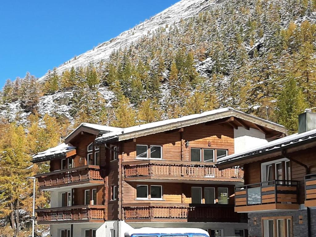un lodge de ski avec une montagne enneigée en arrière-plan dans l'établissement Apartment Alpin Smile by Interhome, à Saas-Almagell