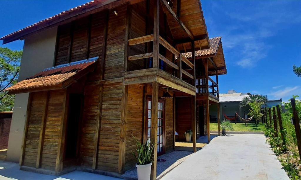 una casa de madera con una escalera lateral en Chalés Rota do Sol Praia do Rosa, en Praia do Rosa