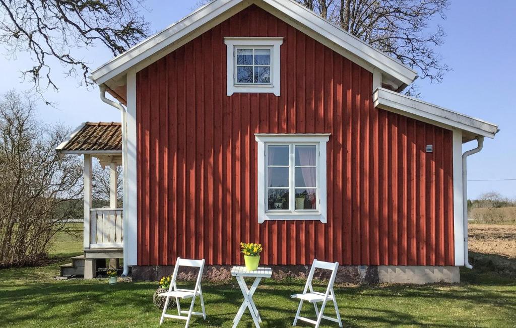 una casa roja con dos sillas delante en Gorgeous Home In Aneby With Wi-fi, en Aneby