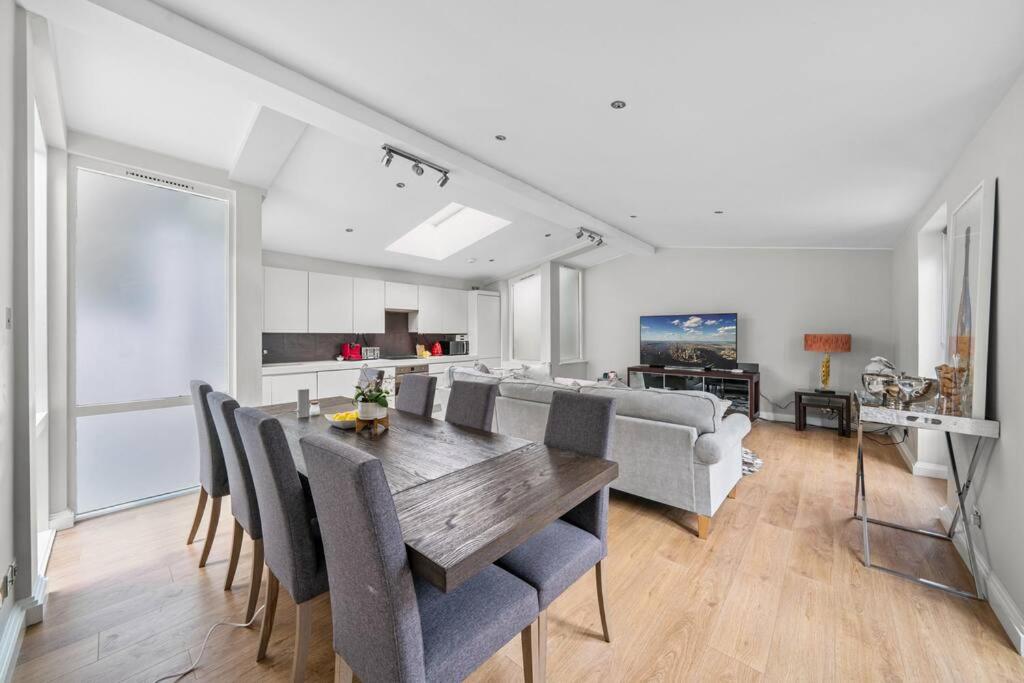 a dining room and living room with a table and chairs at Lovely Mews House Royal Crescent in London