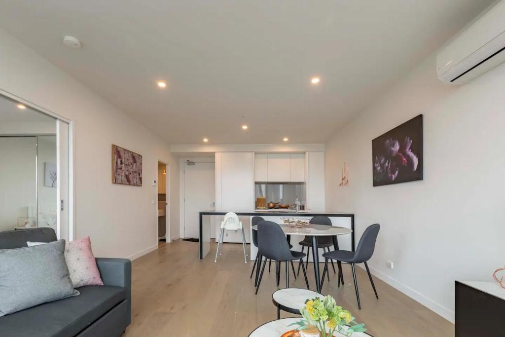 ein Wohnzimmer mit einem Sofa, einem Tisch und Stühlen in der Unterkunft 1 BRM 1 BATH, South Melbourne, Spacious, Balcony in Melbourne