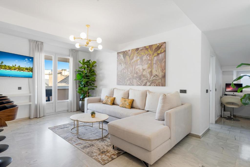 a living room with a white couch and a table at Tennessee Penthouse in Málaga