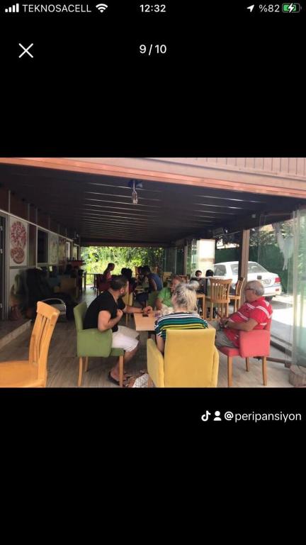 un grupo de personas sentadas en mesas en un restaurante en Peri Pansiyon, en Çınarcık