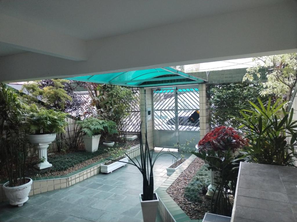 une terrasse avec un parasol bleu et quelques plantes dans l'établissement A melhor localização da PG. Com ar cond.!, à Praia Grande