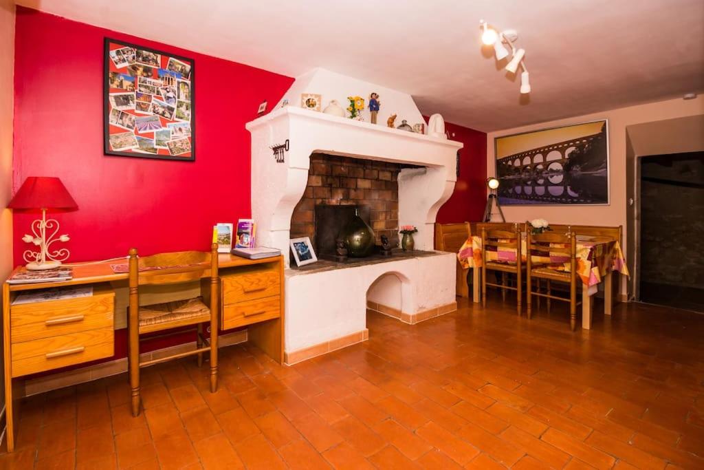 ein Wohnzimmer mit Kamin und ein Esszimmer in der Unterkunft Maison tout confort, climatisée, dans le Centre Historique avec parking privé. in Saint-Rémy-de-Provence