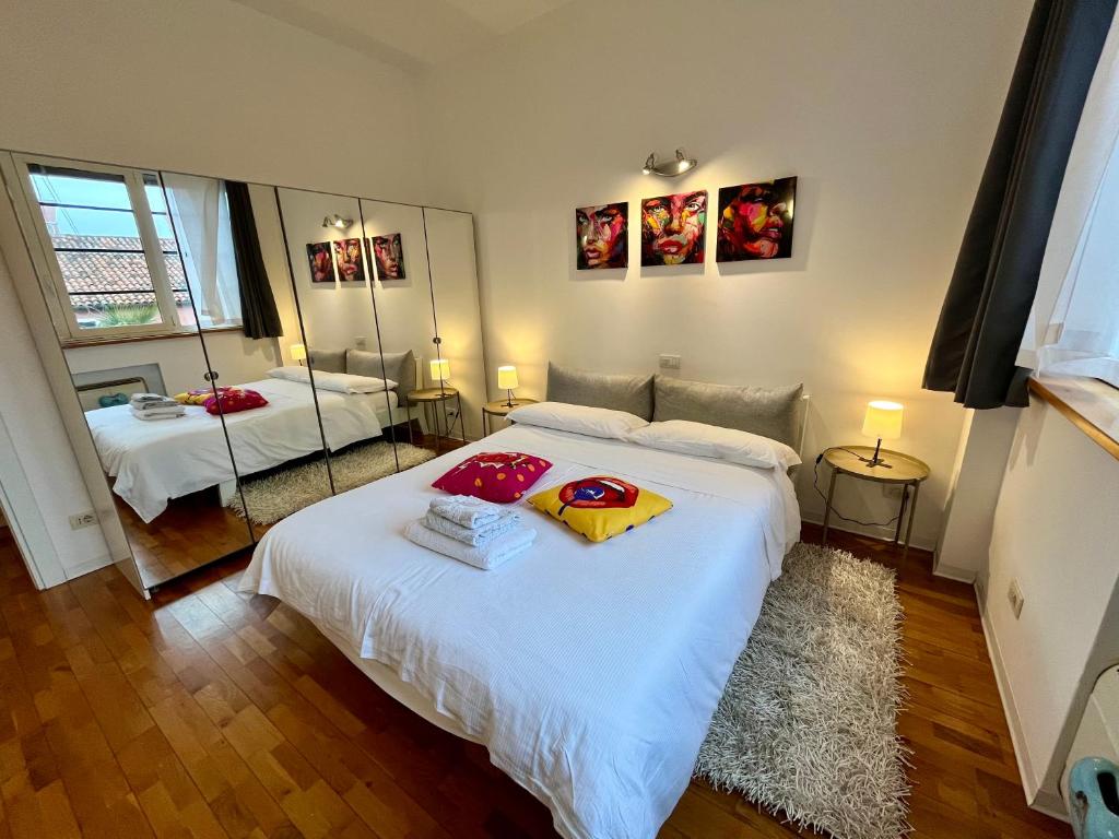 a bedroom with a large white bed and two mirrors at Art District Loft Venice in Venice