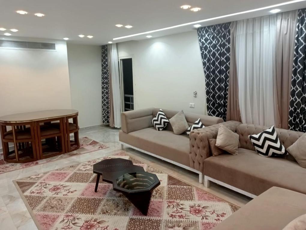 een woonkamer met een bank en een tafel bij لاصحاب التميز شقة راقية في المهندسين بالقرب من جامعة الدول والنيل in Caïro