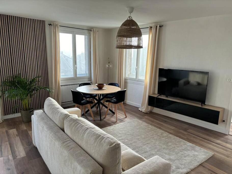 un soggiorno con divano e tavolo di Appartement cosy au cœur de la ville ad Aurillac