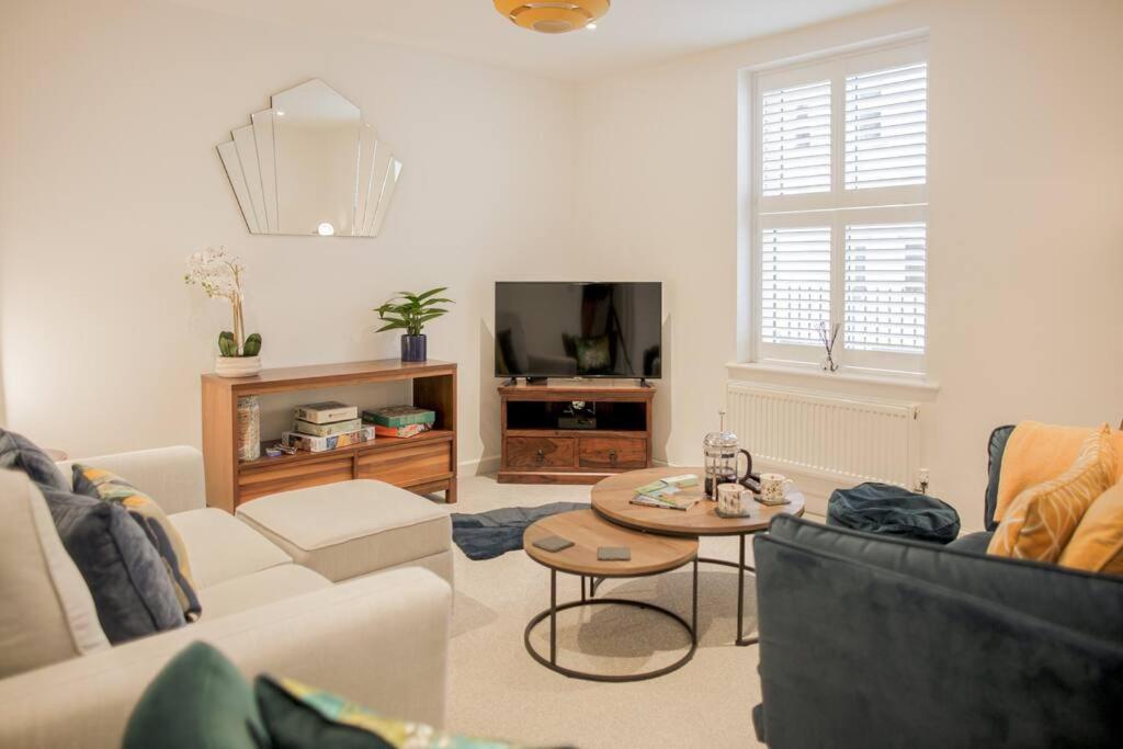 ein Wohnzimmer mit einem Sofa und einem Tisch in der Unterkunft Stunning 2 Bed with Private Patio and Free Parking in Cheltenham
