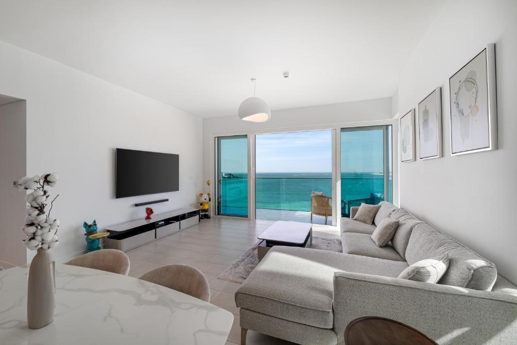a living room with a couch and a tv at 3Bed Private Beach - Belle vie à La Vie Dubai in Dubai