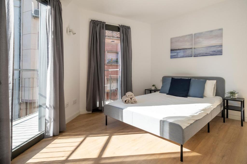 ein Schlafzimmer mit einem Bett und einem großen Fenster in der Unterkunft CENTRIC APARTMENT CAMP NOU 2 in Hospitalet de Llobregat