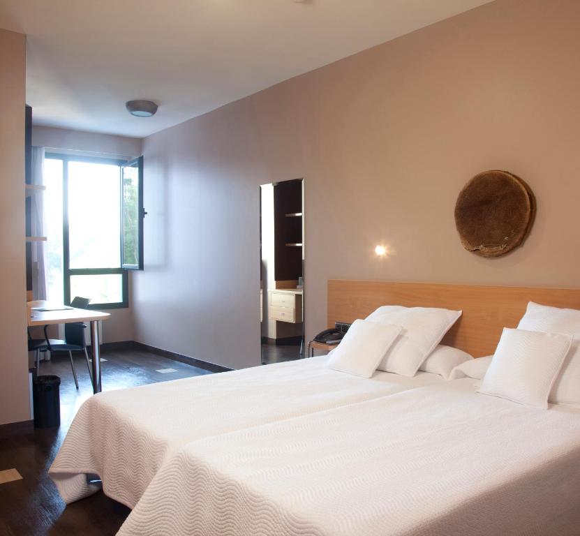 1 dormitorio con 1 cama grande con sábanas blancas en Olarain, en San Sebastián