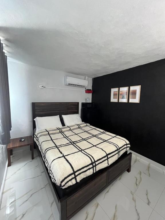 a bedroom with a bed and a black wall at Molinos House 3 in Santa Isabel