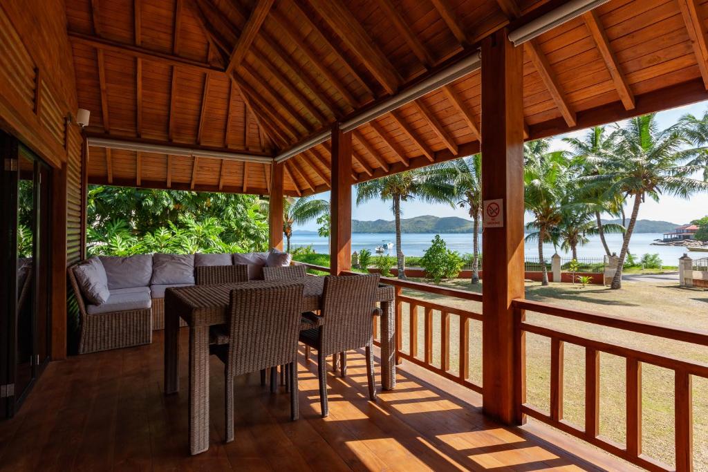 a dining room with a table and chairs on a porch at HideAway in Anse Possession