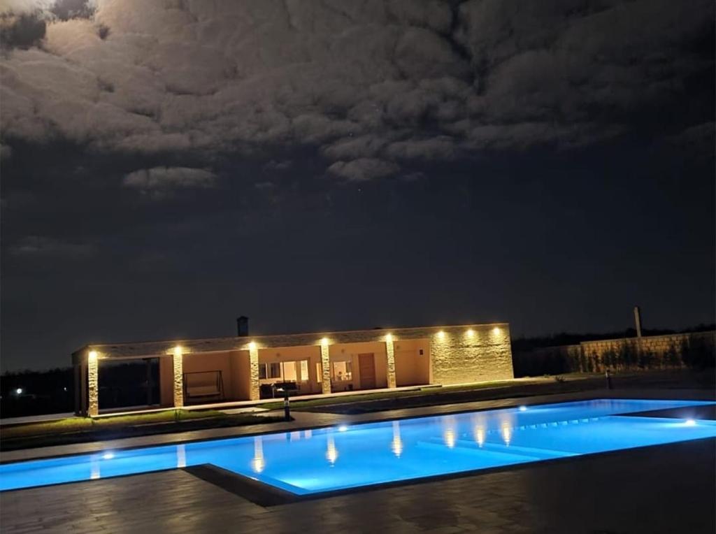 - un bâtiment avec piscine la nuit dans l'établissement Évasio, à Sidi Rahal