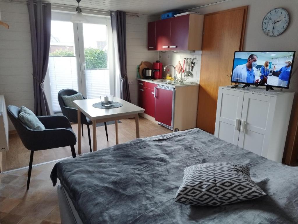 a bedroom with a bed and a kitchen with a tv at FeWo 3 mit Terrasse, Box-Bett, kl extra Zi mit Einzelbett, Tresor in Dahme