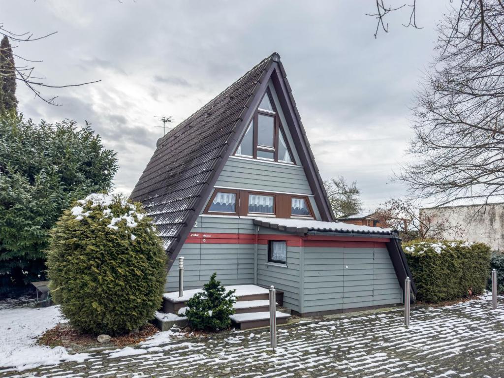 une maison avec un toit en gambrel et un banc devant dans l'établissement Seeblick, à Immenstaad am Bodensee