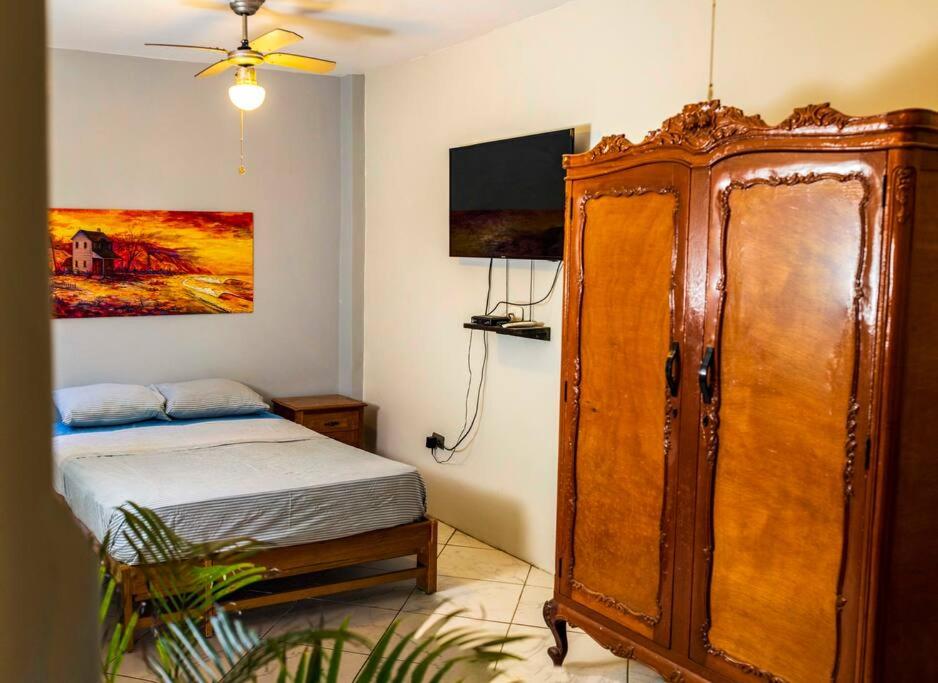 a bedroom with a bed and a large wooden cabinet at Tides Lobitos in Lobitos
