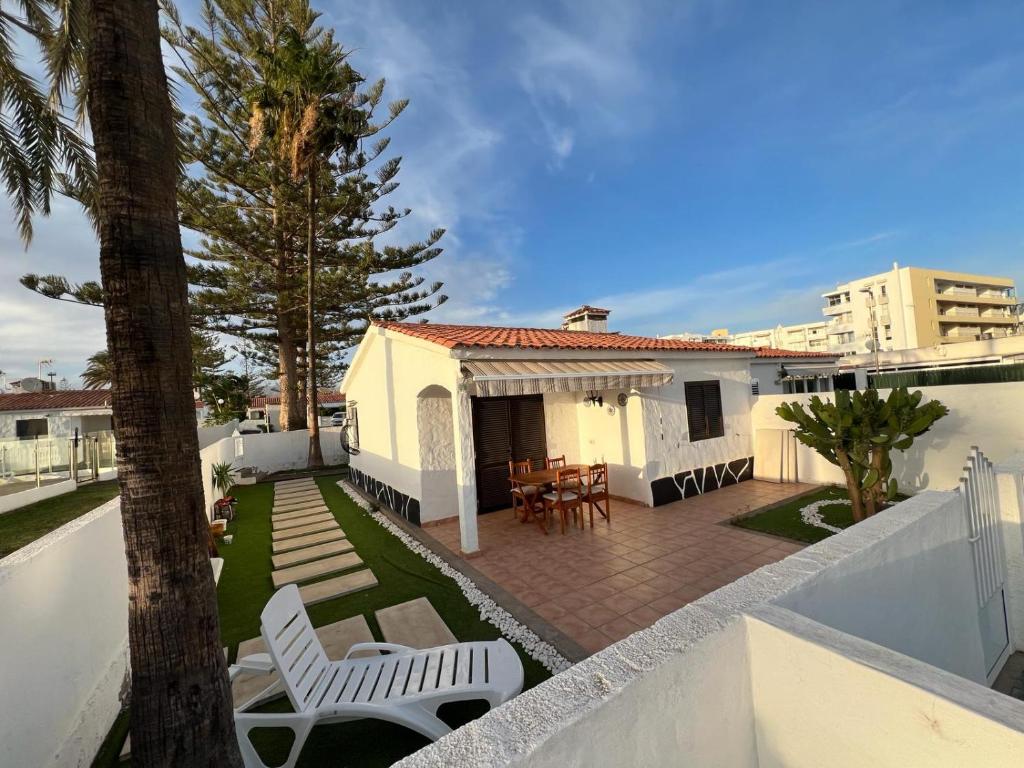 a white house with a patio and a fence at Relaxing Bungalow Playa del Inglés in Maspalomas