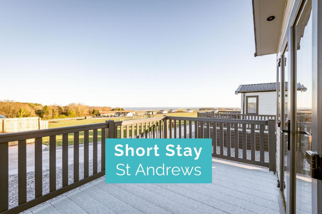 un balcón con una valla y las palabras "estancia corta" en Lodge 2 The Silverdale Close to St Andrews en Strathkinness