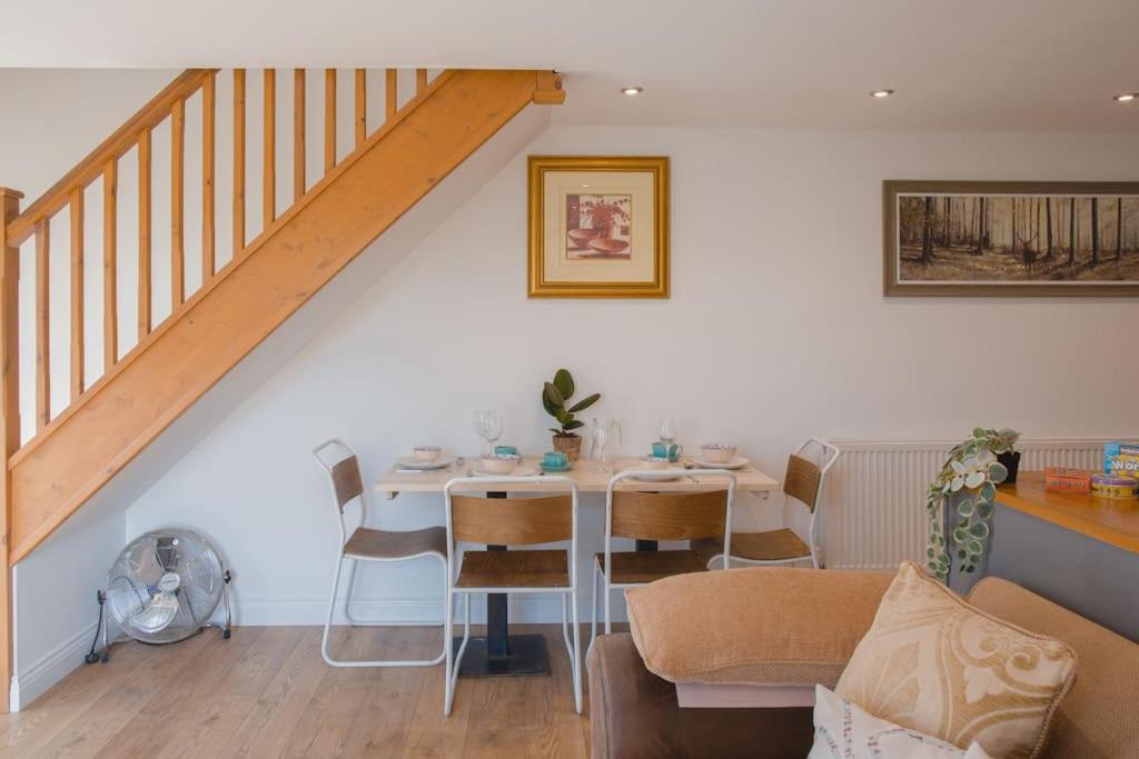 een woonkamer met een tafel en een trap bij Discovery Barn - Luxury 2 Bed Barn Conversion! in Cropthorne